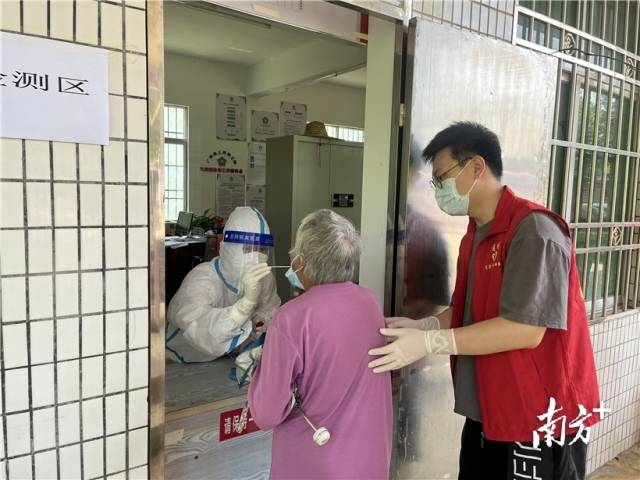現(xiàn)場(chǎng)志愿者幫助行動(dòng)不便群眾接受核酸檢測(cè)。