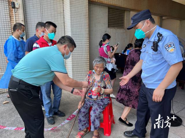 連州市委常委、副市長(zhǎng)、九陂鎮(zhèn)黨委書記綦鴻偉在核酸檢測(cè)現(xiàn)場(chǎng)協(xié)助老人參加核酸檢測(cè)，為老人做好防暑措施。